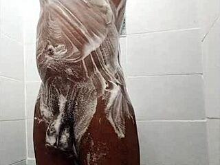 African guy jerks off in the bathroom with his big cock
