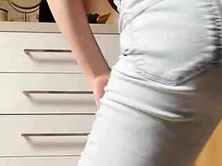 The petite blonde in tight jeans is dancing on the kitchen for you