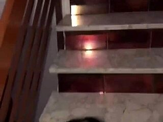 Couple enjoys intimate moments on the stairs, unseen